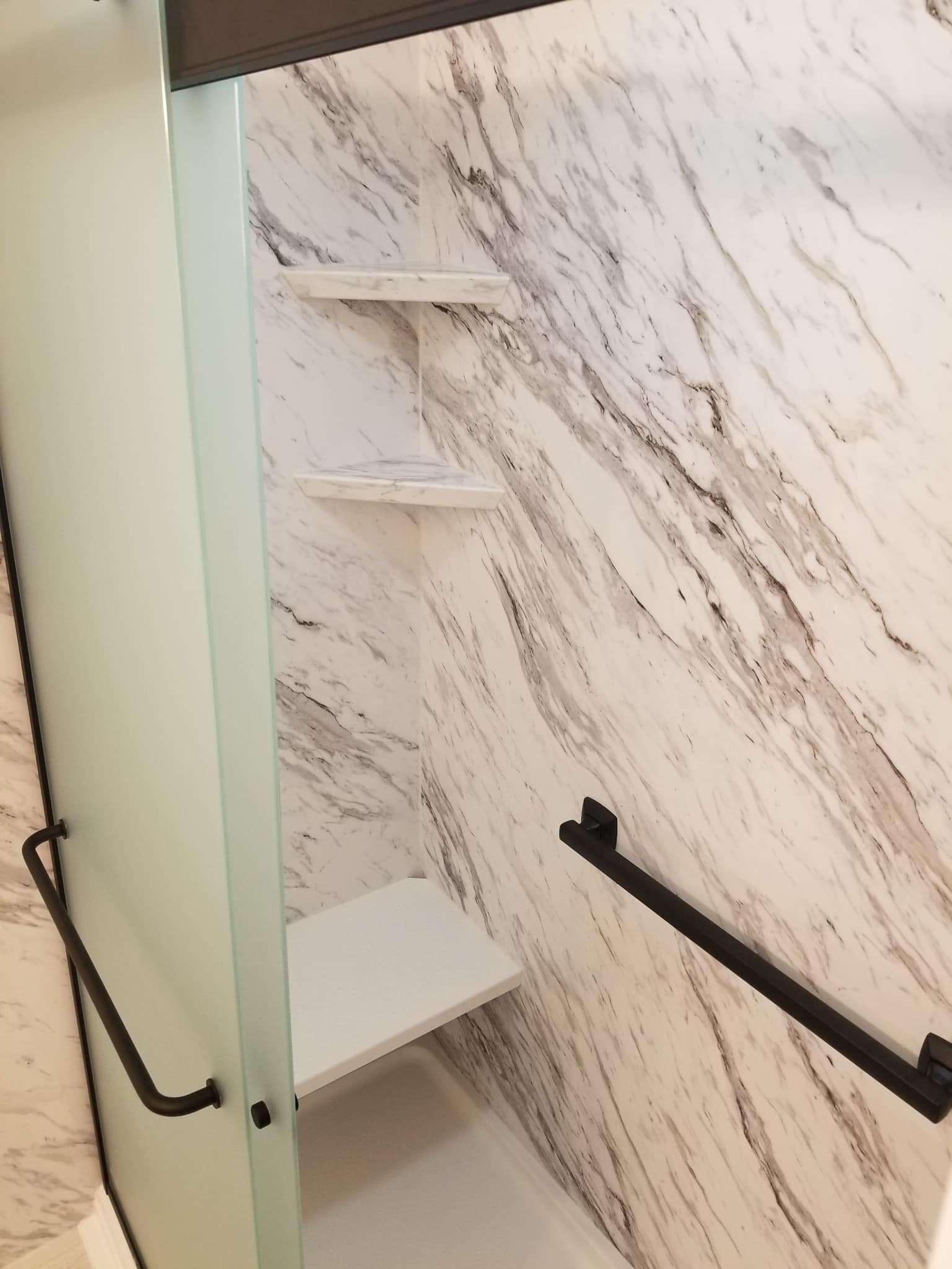 A Recent Bathroom Remodeling Project in Dayton featuring a new shower with our popular Venatino Marble wall system and matte black trim and fixtures.